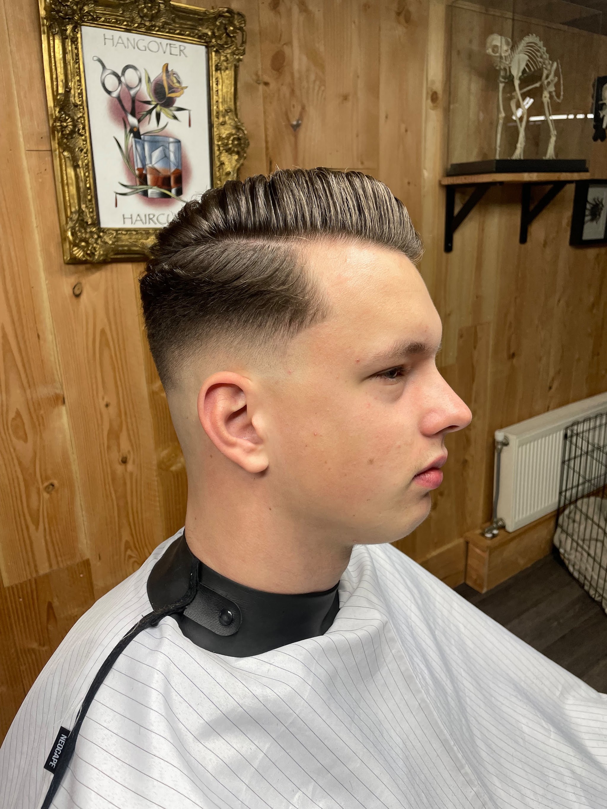 Net geknipte skin fade met een volle kuif, van opzij